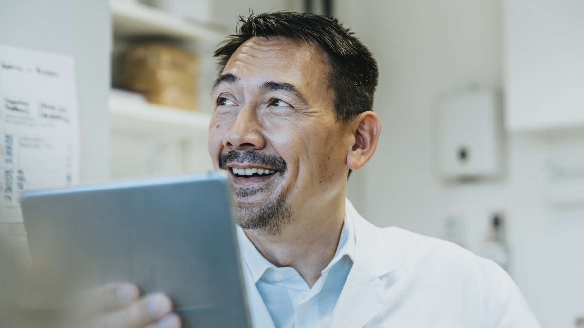 Man smiling with a tablet in hand